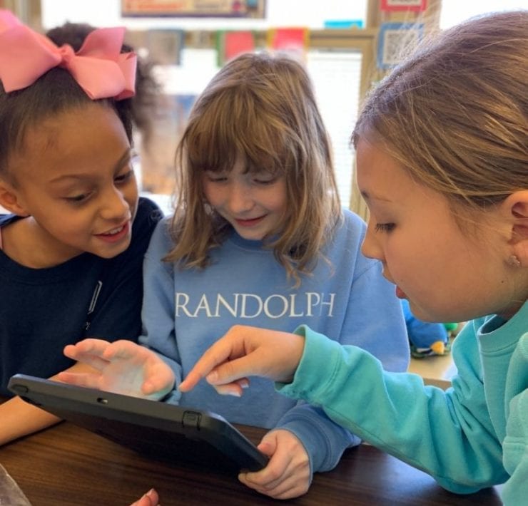 Three Lower School students complete a French lesson using an iPad