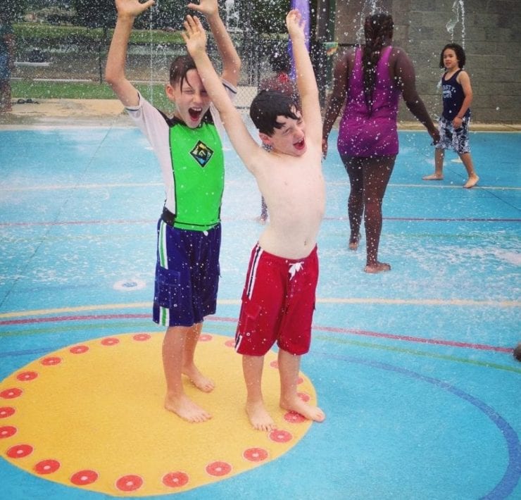 two boys playing in the fountain at the Everybody Can Play Splashpad in Huntsville