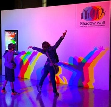 two children playing with their shadows at the exhibit Playing with Light Space & Rocket Center Huntsville