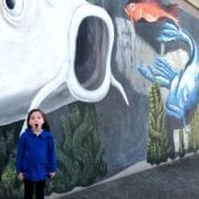 Little girl standing in front of Koi Fish mural in Big Spring Park Huntsville Alabama