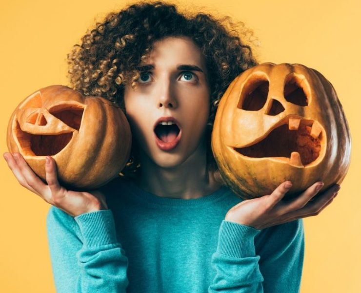 teen holding Halloween pumpkins