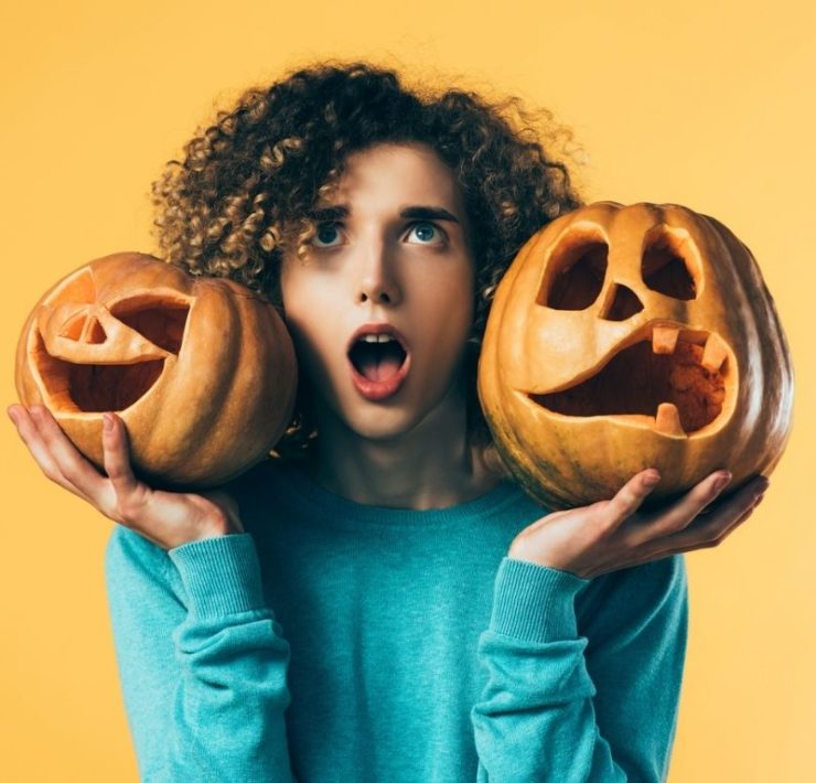 teen holding Halloween pumpkins