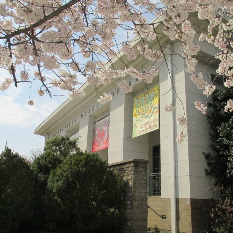 Pink flowers bloom in front of the Huntsville Museum of Art.