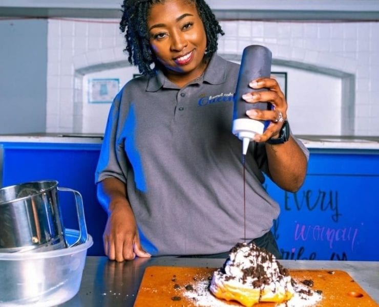 Kenya Congress prepares her funnel cakes with a variety of toppings including chocolate syrup, sprinkles and more at Royalty Funnel Cake.