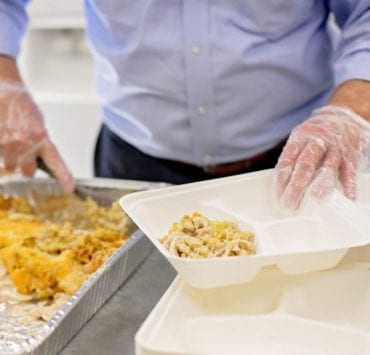 ©Moonbelle Photography A volunteer serves a hot meal at First Stop to help serve the homeless population in Huntsville.