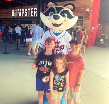 three kids at Toyota Stadium with Trash Panda mascot, Sprocket