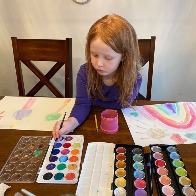 kindergarten girl painting at a table
