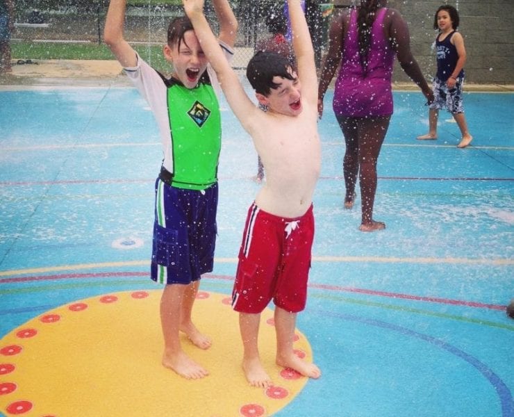 two boys playing in the fountain at the Everybody Can Play Splashpad in Huntsville