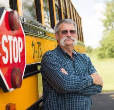 Tom Brandon in front of school bus