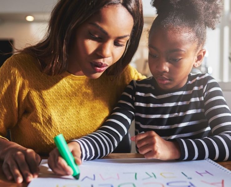 mother and daughter practicing writing alphabet
