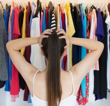 woman looking at her closet of clothes