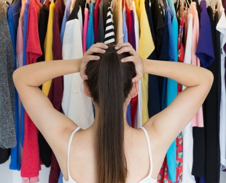 woman looking at her closet of clothes