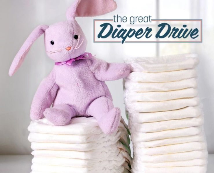 stuffed rabbit sitting on a stack of diapers
