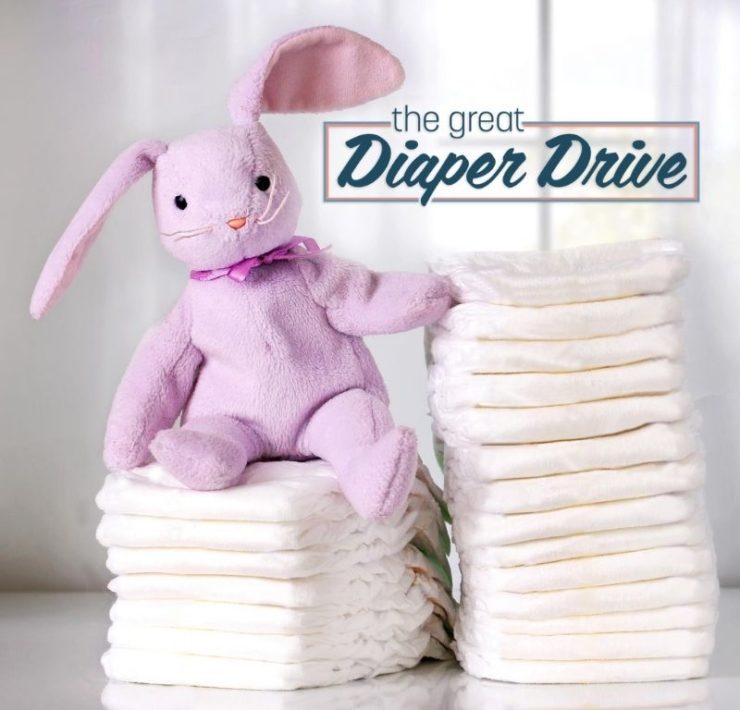 stuffed rabbit sitting on a stack of diapers