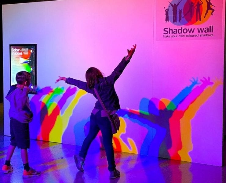 two children playing with their shadows at the exhibit Playing with Light Space & Rocket Center Huntsville
