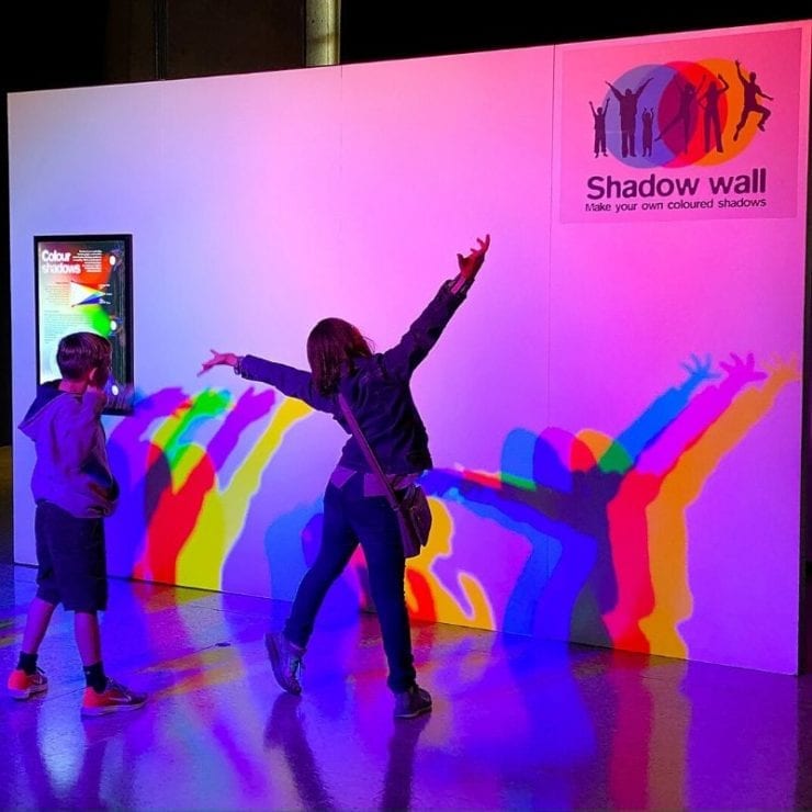 two children playing with their shadows at the exhibit Playing with Light Space & Rocket Center Huntsville