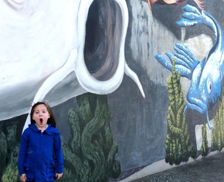Little girl standing in front of Koi Fish mural in Big Spring Park Huntsville Alabama