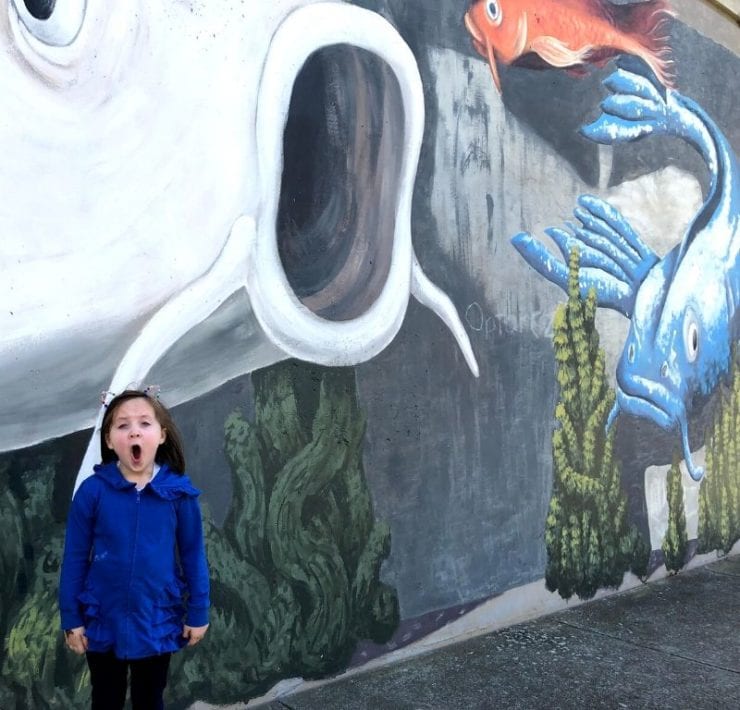 Little girl standing in front of Koi Fish mural in Big Spring Park Huntsville Alabama