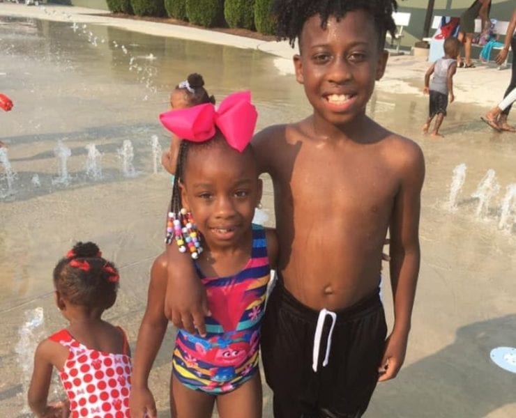 three children at the Showers Center splash pad