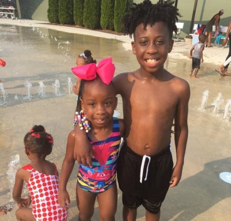 three children at the Showers Center splash pad