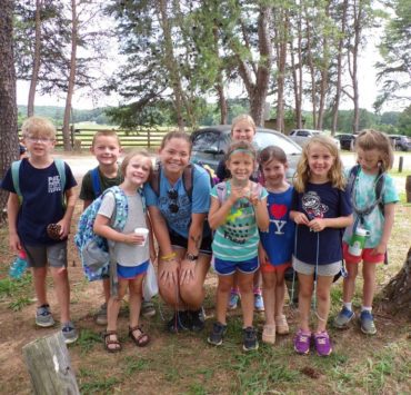 A group of school age kids huddle together at Pine Ridge camp in between activities for a group photo.
