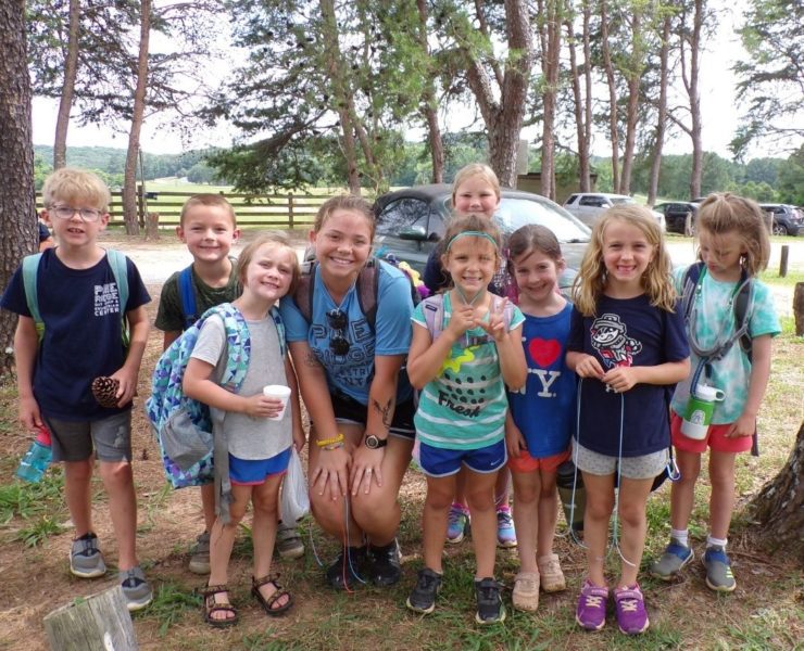 A group of school age kids huddle together at Pine Ridge camp in between activities for a group photo.