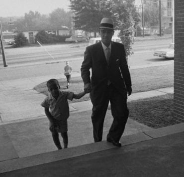 Sonnie Hereford IV walks with his father to school as the first black child to be enrolled in a public school in Alabama.
