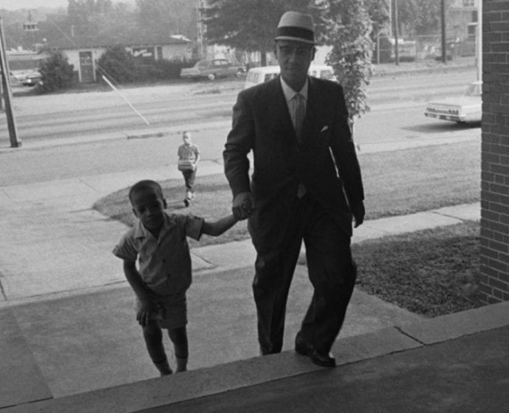 Sonnie Hereford IV walks with his father to school as the first black child to be enrolled in a public school in Alabama.