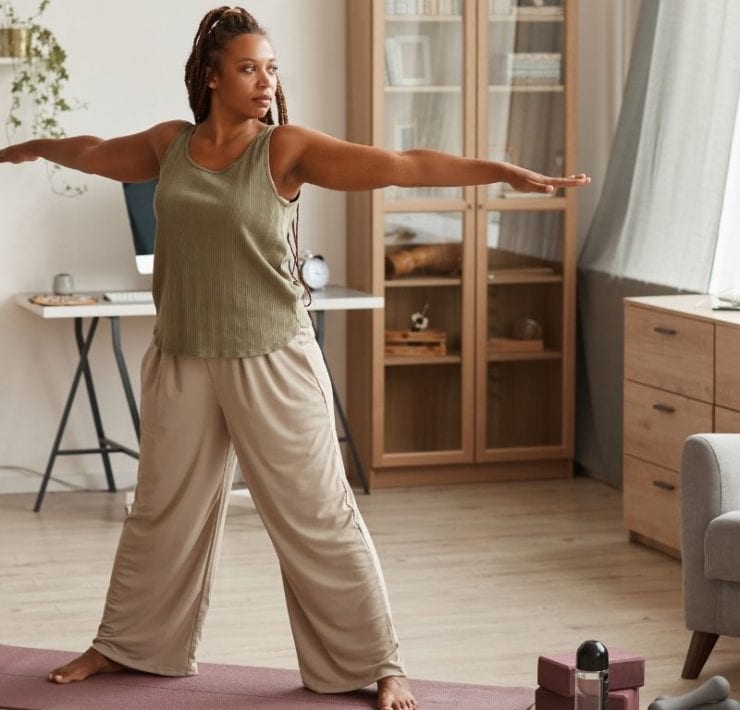 black woman doing yoga exercises in her living room