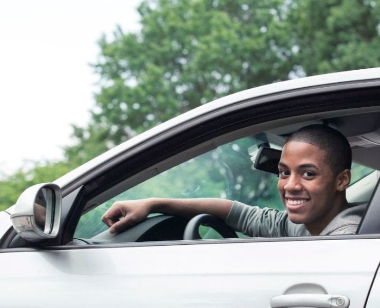 young Black teen driving a car