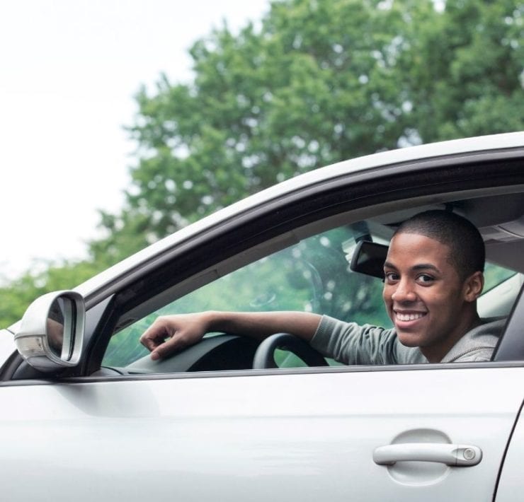 young Black teen driving a car