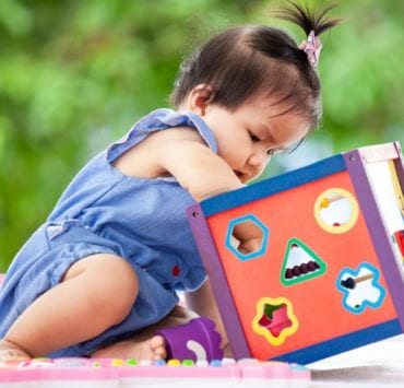 A child playing with a toy is a sample photo of what we're looking for in the Kids of the Week series.