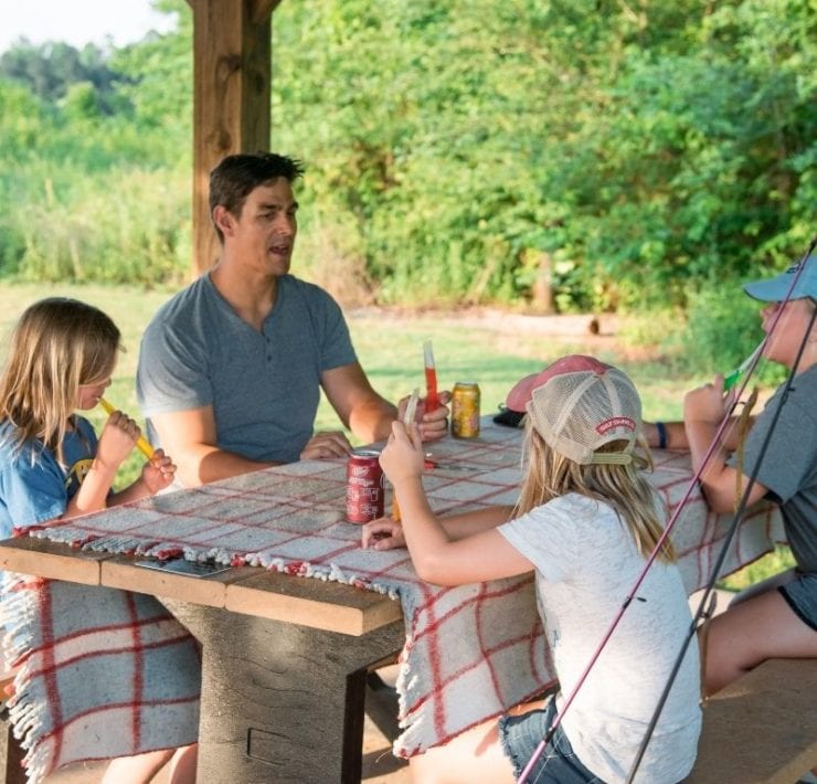 A family enjoys a picnic after a day of fishing at the Land Trust.