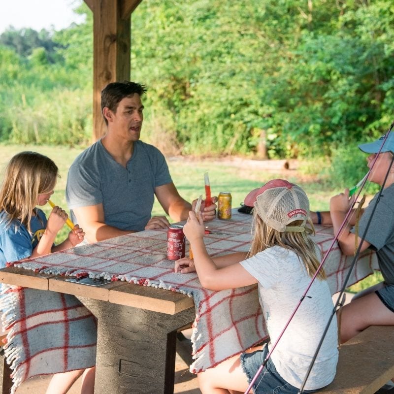 A family enjoys a picnic after a day of fishing at the Land Trust.