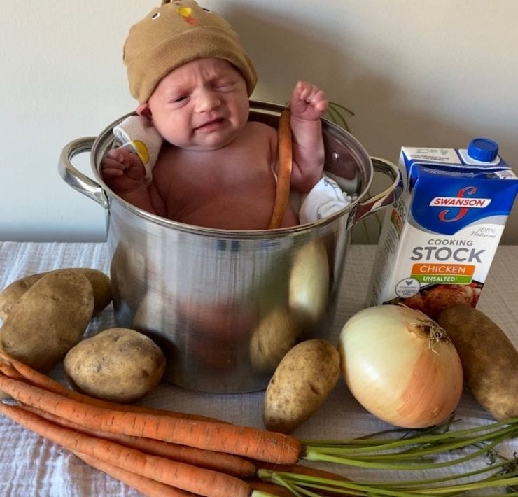 This cute DIY photoshoot idea features a baby in a turkey hat inside a large stock pot surrounded by chicken stock and veggies.
