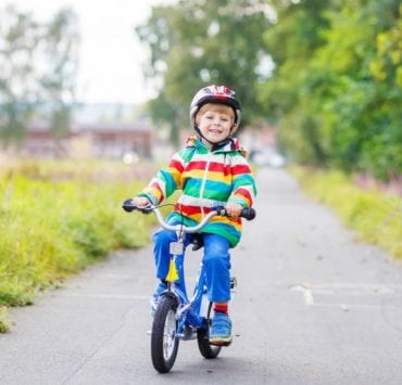 boy riding his bike on paved path