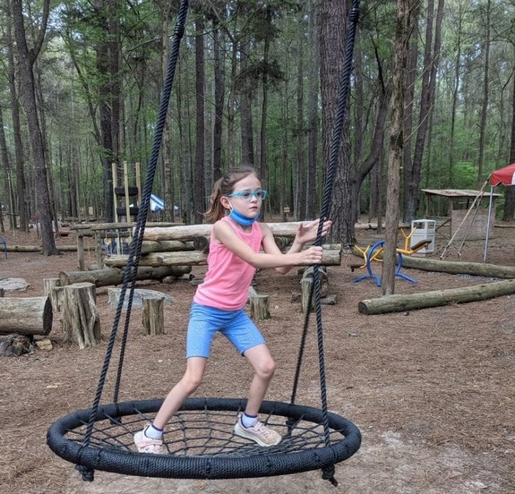 A girl swings in a large netted swing at GoFAR USA Park.