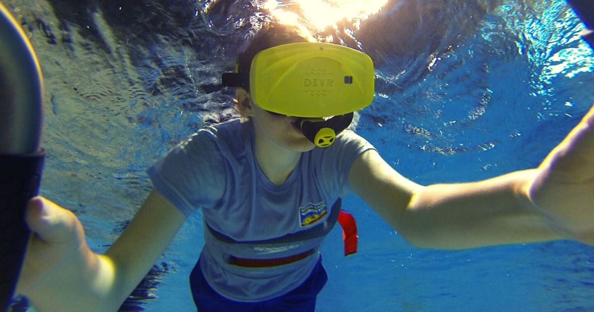boy swimming in the astronaut training tank at the Space & Rocket Center while using a virtual reality set