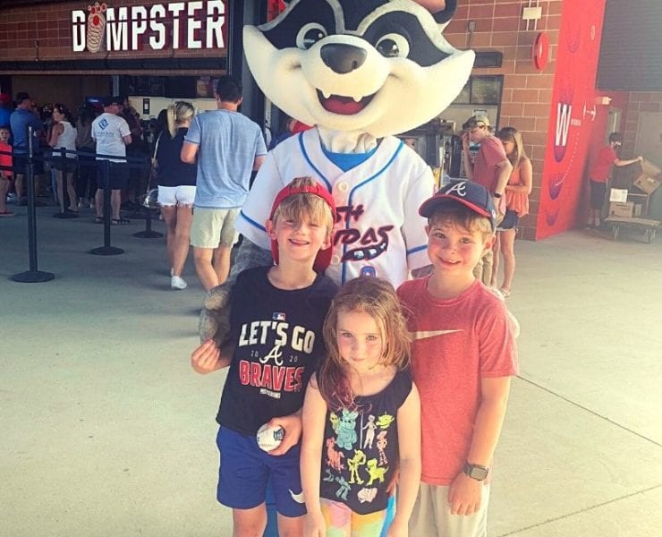 three kids at Toyota Stadium with Trash Panda mascot, Sprocket