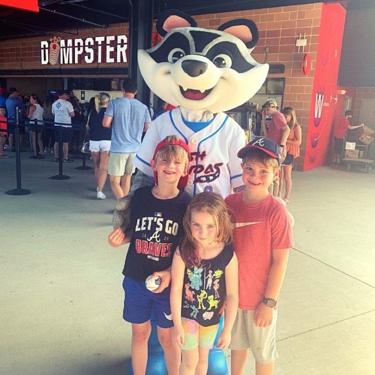 three kids at Toyota Stadium with Trash Panda mascot, Sprocket
