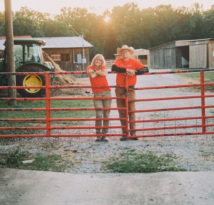 LeAnn and Scott Newsom stand at the gates of Haven Farm.