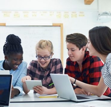 Students around laptops in classroom