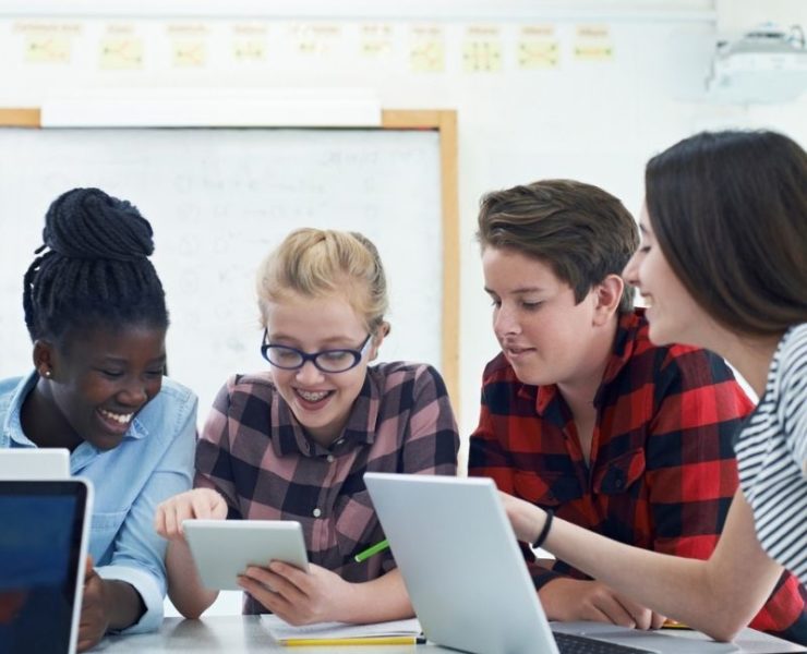 Students around laptops in classroom