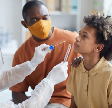 father and son in a doctors office getting a covid test