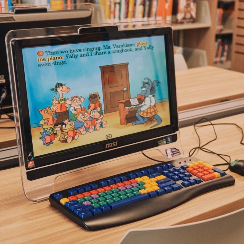 A children's game fills the screen of a computer with a brightly colored keyboard and child-sized mouse.