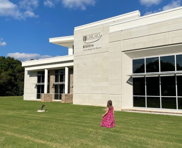 A girl walks outside the front of the new South Huntsville Library location.