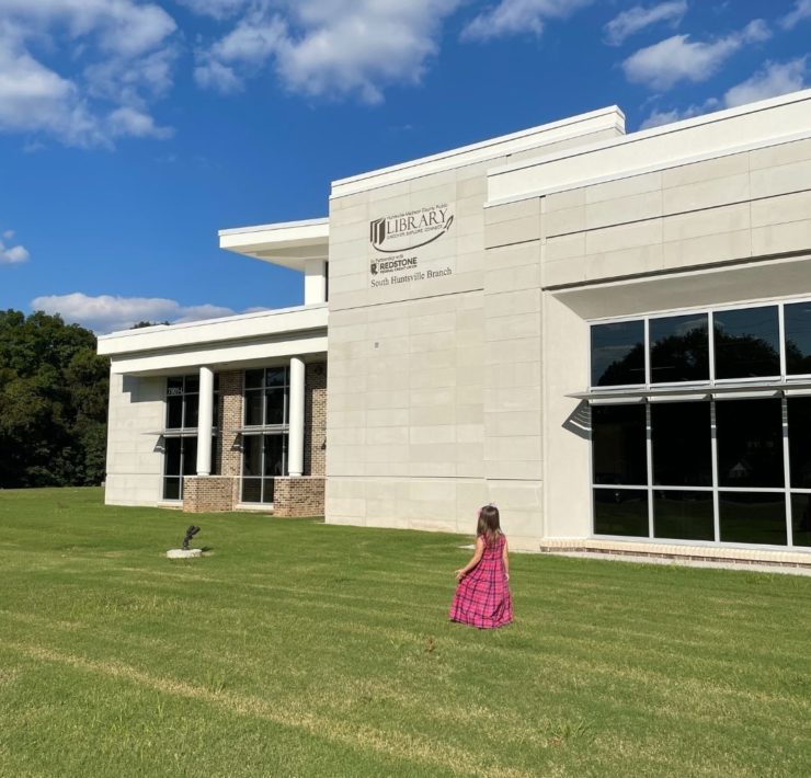 A girl walks outside the front of the new South Huntsville Library location.