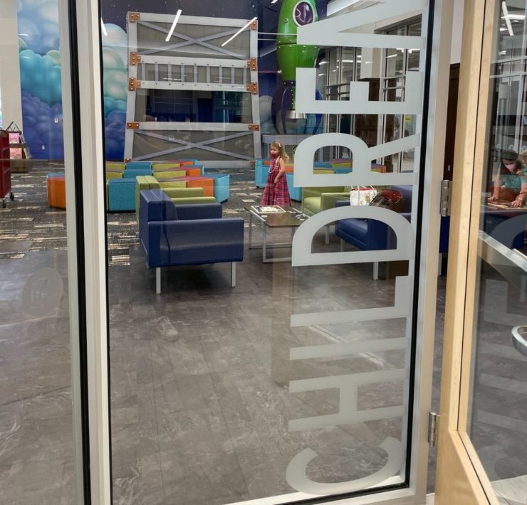 A glass door looks into the designated children's area at the library.