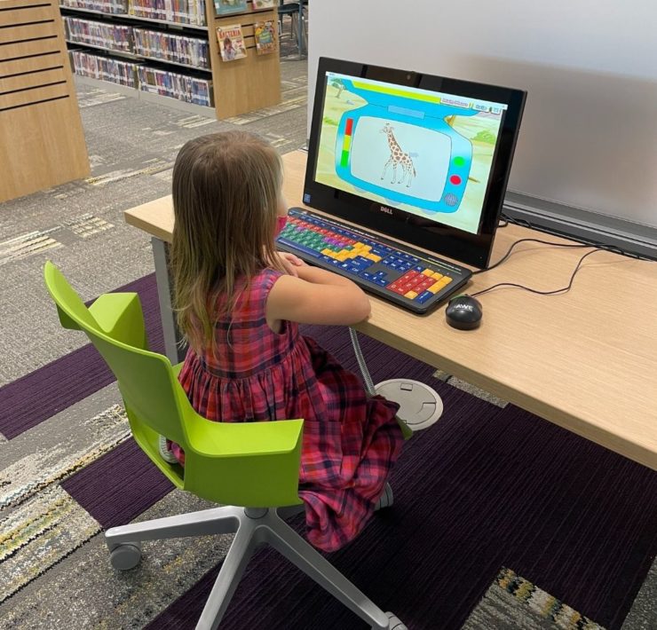 A young girl plays on the computer in the South Huntsville Library's children's area.