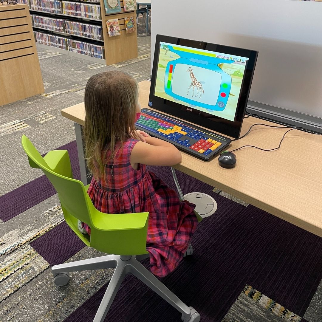 A young girl plays on the computer in the South Huntsville Library's children's area.